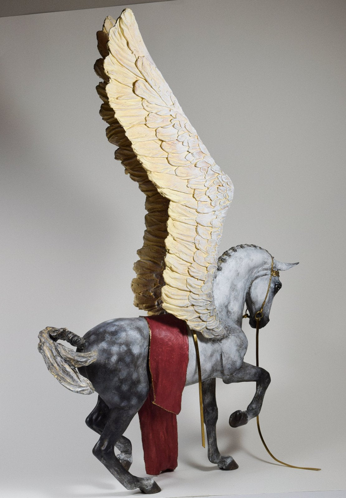 Pegasus with wings raised and gold bridle sculpture