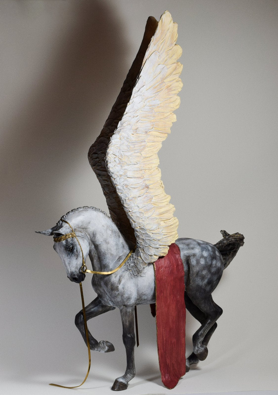 Pegasus with wings raised and gold bridle sculpture