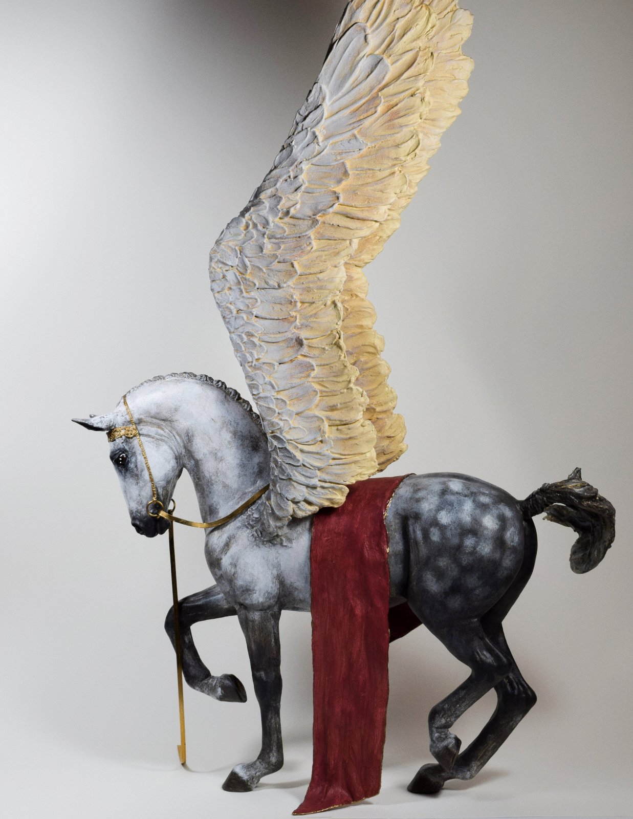 Pegasus with wings raised and gold bridle sculpture