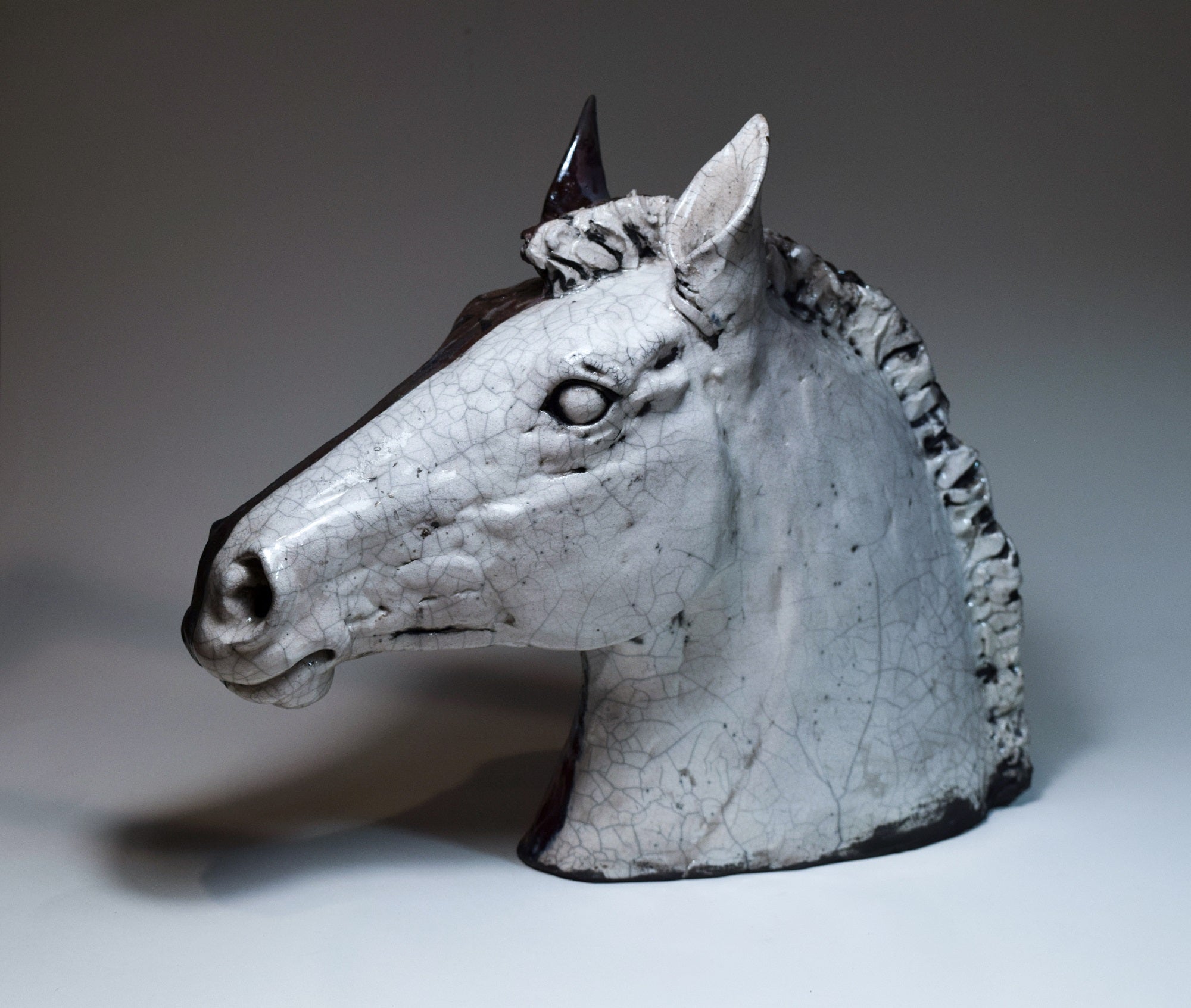 Raku ceramic horse head in black and white by Susie Benes