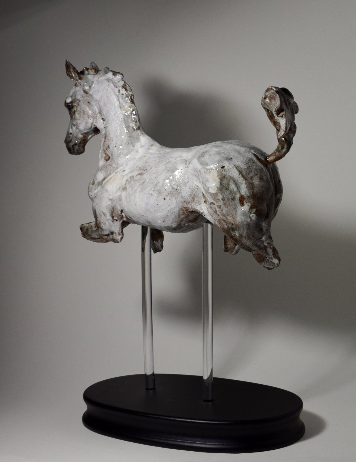 Grey white cantering ceramic horse sculpture on wood base by Susie Benes