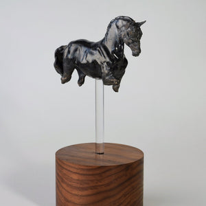 Black ceramic horse sculpture on tall wood base