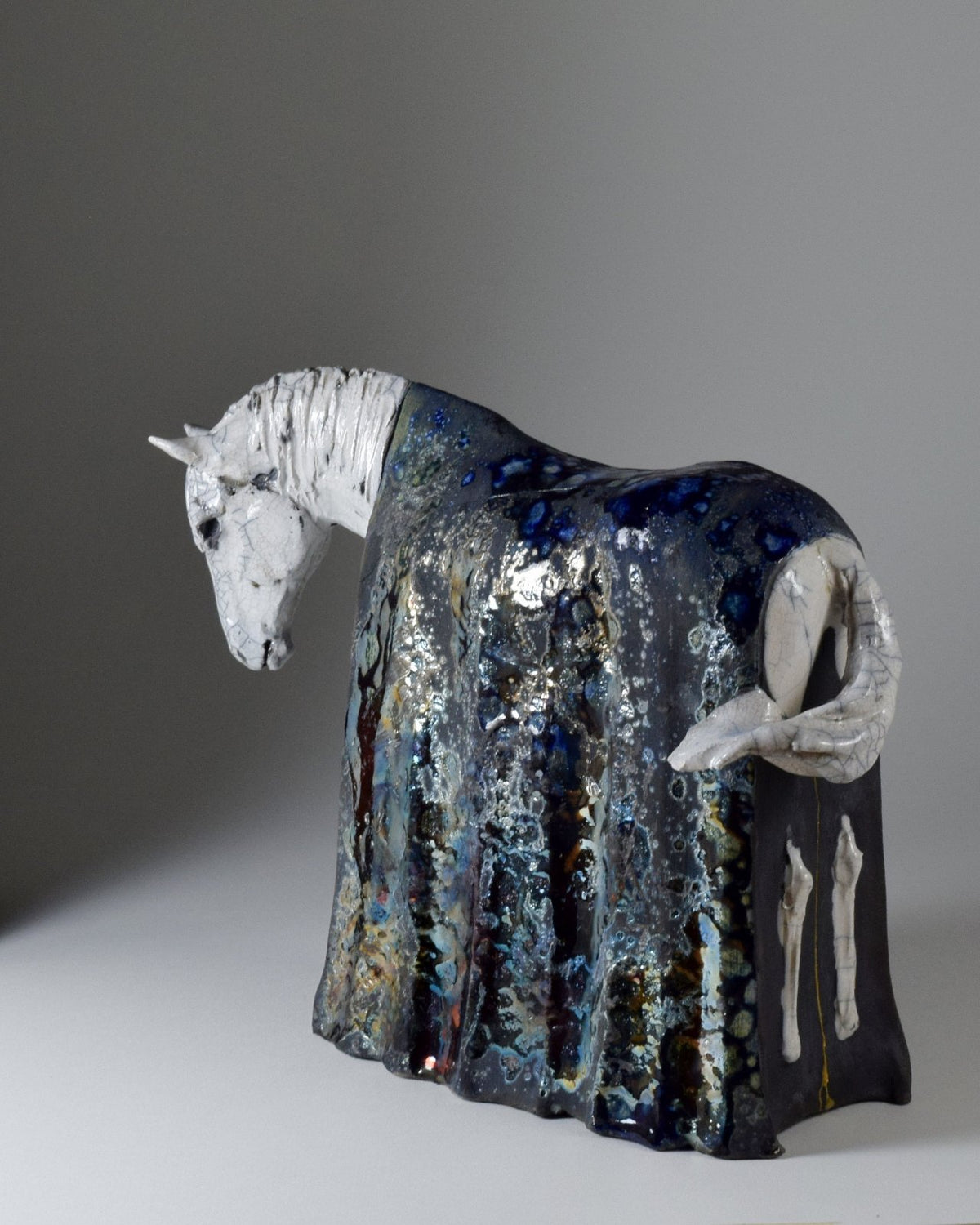 White and metallic ceramic horse sculpture by Susie Benes