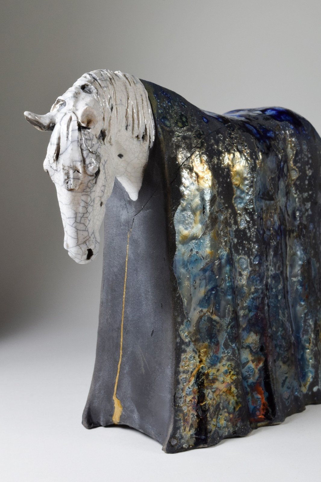 White and metallic ceramic horse sculpture by Susie Benes