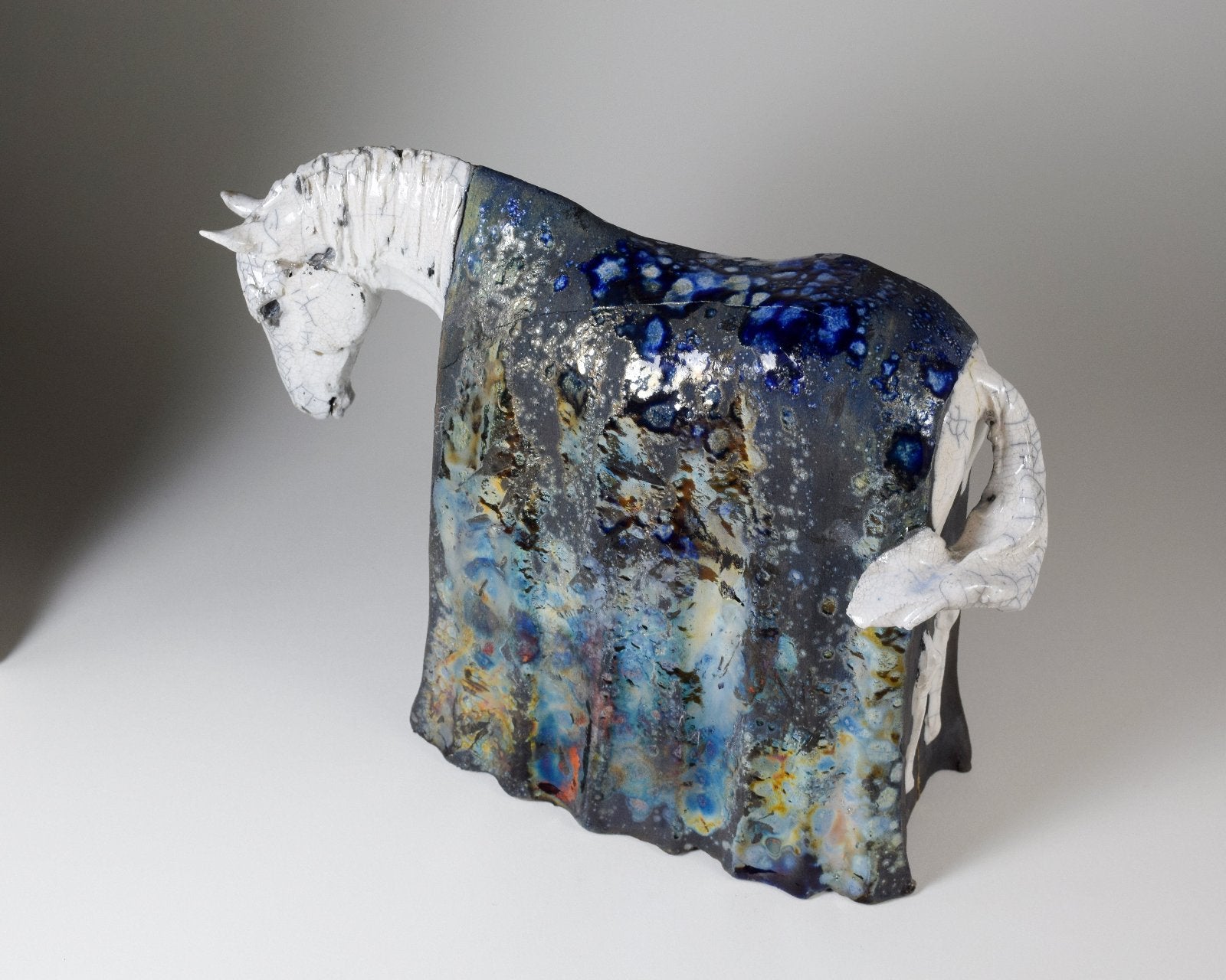 White and metallic ceramic horse sculpture by Susie Benes